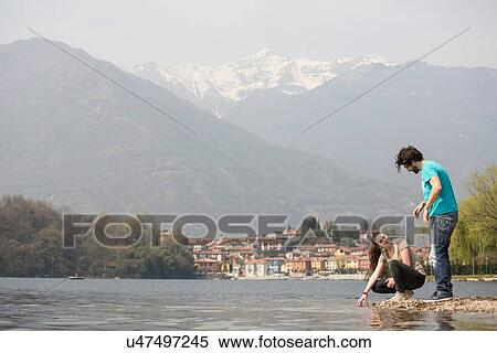 Stock Photography - Young couple on lakeside, Lake Mergozzo, Verbania, Piemonte, Italy. Fotosearch