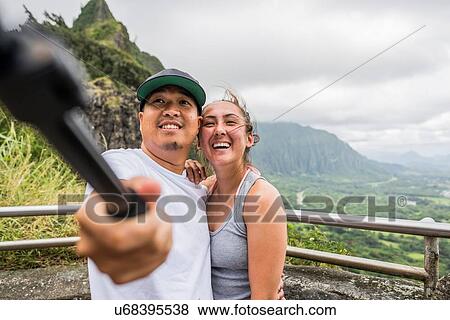 Young couple pointing from viewing platform, Nuuanu Pali, Oahu, Hawaii, USA View Large Photo Image Stock Photo - Young couple pointing from viewing platform, Nuuanu Pali, Oahu, Hawaii, USA. Fotosearch