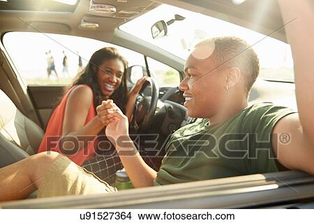 Young couple sitting in car holding hands View Large Photo Image Picture - Young couple sitting in car holding hands. Fotosearch