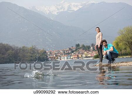 Young couple skimming stones in Lake Mergozzo, Verbania, Piemonte, Italy View Large Photo Image Stock Image - Young couple skimming stones in Lake Mergozzo, Verbania, Piemonte, Italy. Fotosearch