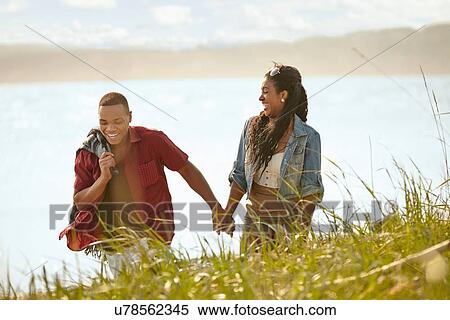 Stock Photography - Young couple strolling holding hands. Fotosearch
