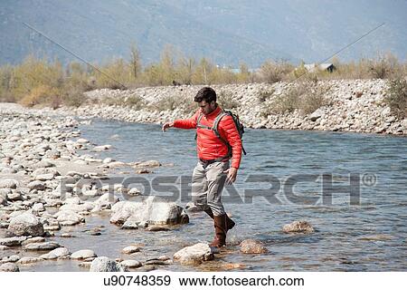 Young male hiker crossing Toce river, Vogogna, Verbania, Piemonte, Italy View Large Photo Image Stock Photo - Young male hiker crossing Toce river, Vogogna, Verbania, Piemonte, Italy. Fotosearch