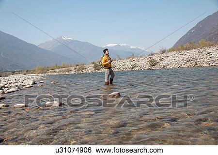 Young male hiker looking out from Toce river, Vogogna, Verbania, Piemonte, Italy View Large Photo Image Stock Photograph - Young male hiker looking out from Toce river, Vogogna, Verbania, Piemonte, Italy. Fotosearch