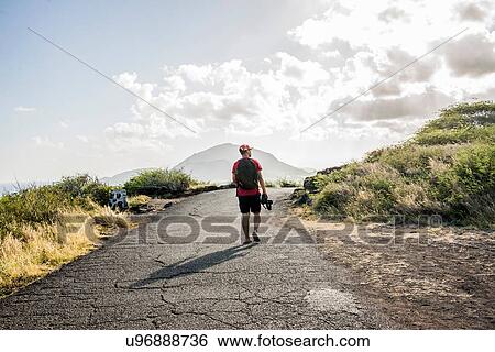 Young male tourist strolling with digital SLR on Makapuu coast path, Oahu, Hawaii, USA View Large Photo Image Stock Photograph - Young male tourist strolling with digital SLR on Makapuu coast path, Oahu, Hawaii, USA. Fotosearch