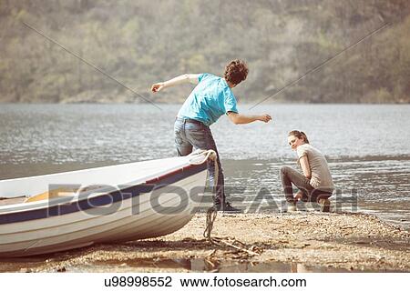 Young man and girlfriend skimming stones in Lake Mergozzo, Verbania, Piemonte, Italy View Large Photo Image Stock Image - Young man and girlfriend skimming stones in Lake Mergozzo, Verbania, Piemonte, Italy. Fotosearch