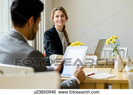 Young man and woman in cafe using laptop and digital tablet View Large Photo Image Stock Photograph - Young man and woman in cafe using laptop and digital tablet. Fotosearch