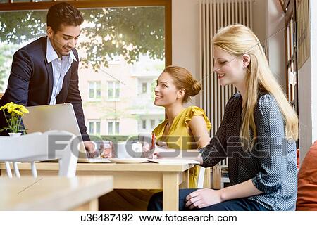 Young man chatting to young woman in cafe View Large Photo Image Stock Image - Young man chatting to young woman in cafe. Fotosearch