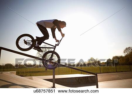 Stock Image - Young man doing stunt on bmx at skatepark. Fotosearch
