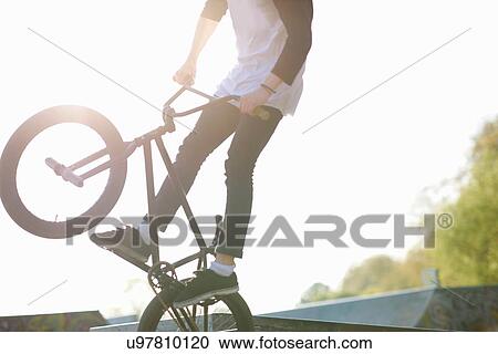 Young man doing stunt on bmx at skatepark View Large Photo Image Stock Image - Young man doing stunt on bmx at skatepark. Fotosearch
