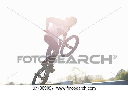 Young man doing stunt on bmx at skatepark View Large Photo Image Stock Photo - Young man doing stunt on bmx at skatepark. Fotosearch