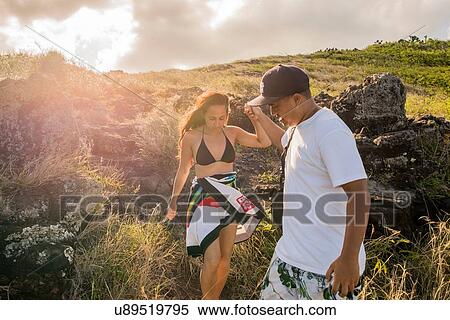 Young man giving girlfriend a helping hand on Makapuu coast path, Oahu, Hawaii, USA View Large Photo Image Stock Photography - Young man giving girlfriend a helping hand on Makapuu coast path, Oahu, Hawaii, USA. Fotosearch
