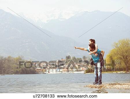 Young man giving girlfriend piggyback on lakeside, Lake Mergozzo, Verbania, Piemonte, Italy View Large Photo Image Stock Image - Young man giving girlfriend piggyback on lakeside, Lake Mergozzo, Verbania, Piemonte, Italy. Fotosearch