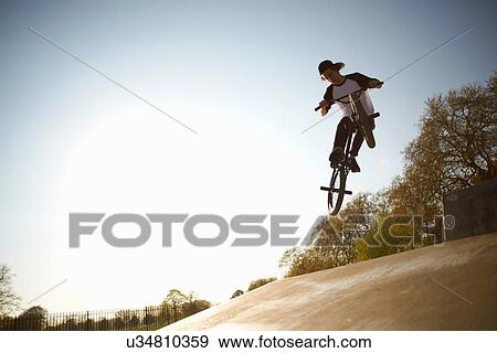 Young man, in mid air, doing stunt on bmx at skatepark View Large Photo Image Stock Photo - Young man, in mid air, doing stunt on bmx at skatepark. Fotosearch