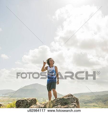 Young man making shaka hand sign on Makapuu coast path, Oahu, Hawaii, USA View Large Photo Image Stock Photo - Young man making shaka hand sign on Makapuu coast path, Oahu, Hawaii, USA. Fotosearch