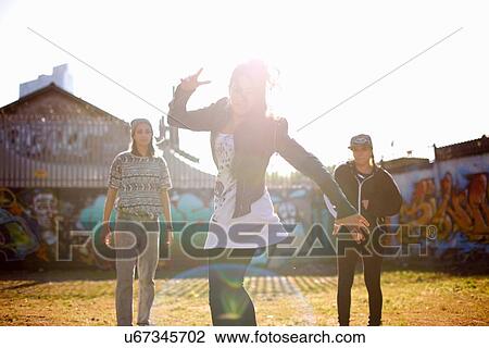 Stock Image - Young woman dancing in the sunshine, backlit. Fotosearch