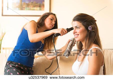 Young woman doing friend's hair View Large Photo Image Stock Photo - Young woman doing friend's hair. Fotosearch