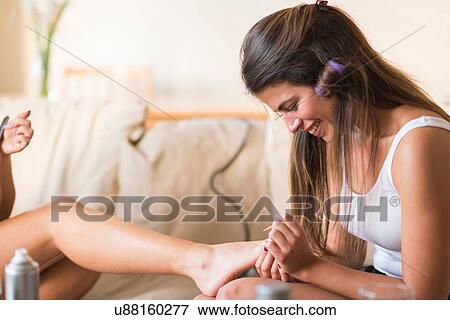 Young woman painting friend's toenails View Large Photo Image Stock Photo - Young woman painting friend's toenails. Fotosearch