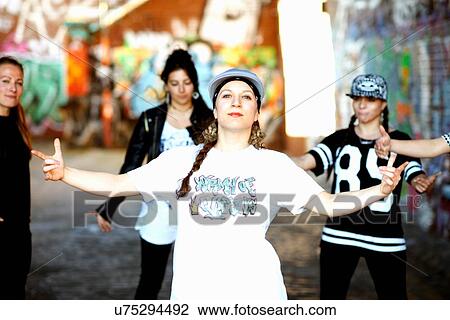 Young woman standing arms open, looking at camera with attitude View Large Photo Image Stock Image - Young woman standing arms open, looking at camera with attitude. Fotosearch