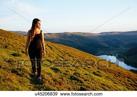 Stock Photo - Young woman strolling, Talybont Reservoir in Glyn Collwn valley, Brecon Beacons, Powys, Wales. Fotosearch
