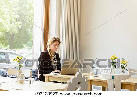 Young woman typing on laptop in cafe View Large Photo Image Stock Photo - Young woman typing on laptop in cafe. Fotosearch