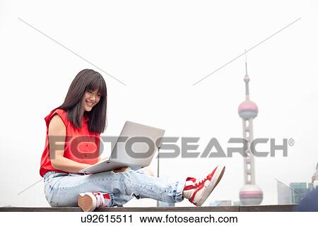 Young woman using laptop, outdoors, Shanghai, China View Large Photo Image Stock Image - Young woman using laptop, outdoors, Shanghai, China. Fotosearch
