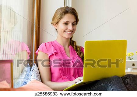 Young woman using yellow laptop in cafe View Large Photo Image Stock Image - Young woman using yellow laptop in cafe. Fotosearch