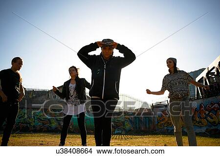 Picture - Young woman wearing baseball cap looking at camera. Fotosearch