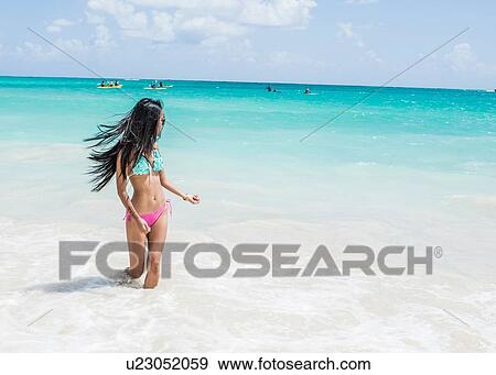 Young woman wearing bikini paddling in sea on Kailua beach, Oahu, Hawaii, USA View Large Photo Image Stock Photo - Young woman wearing bikini paddling in sea on Kailua beach, Oahu, Hawaii, USA. Fotosearch