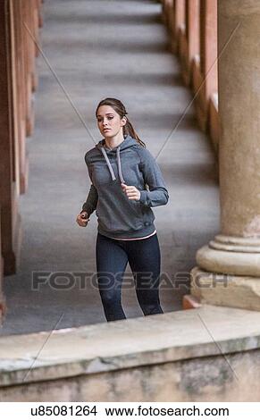Picture - Young woman wearing sports clothes jogging. Fotosearch