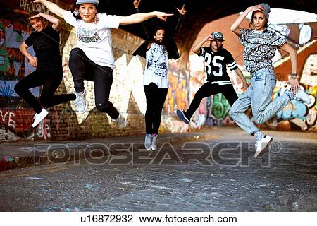 Stock Image - Young women jumping in mid air. Fotosearch