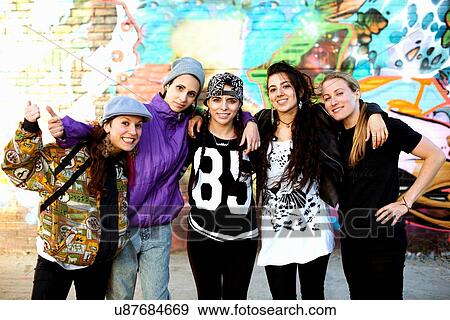 Young women standing with arms around each other, looking at camera View Large Photo Image Stock Photo - Young women standing with arms around each other, looking at camera. Fotosearch