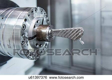 Stock Photograph - Artificial hip joint in CNC lathe in orthopaedic factory, close up. Fotosearch