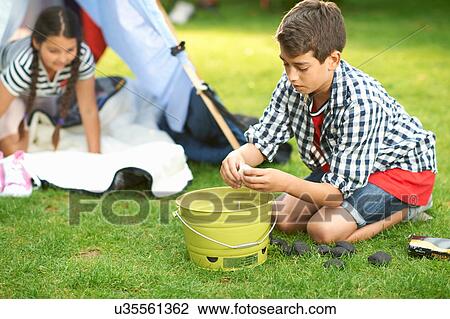 Boy preparing firelighters for campfire in garden View Large Photo Image Stock Image - Boy preparing firelighters for campfire in garden. Fotosearch
