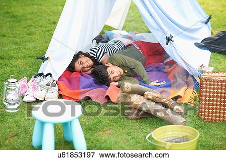 Brother and sister lying in homemade tent in garden View Large Photo Image Stock Photo - Brother and sister lying in homemade tent in garden. Fotosearch