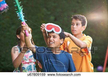 Children playing pinata in garden View Large Photo Image Stock Photo - Children playing pinata in garden. Fotosearch