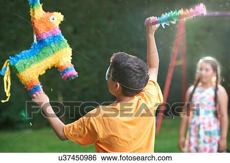 Stock Photograph - Children playing pinata in garden. Fotosearch