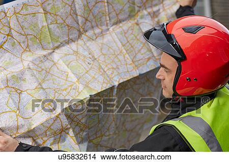 Picture - Close up of motor scooter rider reading London map. Fotosearch