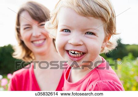 Close up portrait of mid adult mother and toddler daughter in flower field View Large Photo Image Picture - Close up portrait of mid adult mother and toddler daughter in flower field. Fotosearch