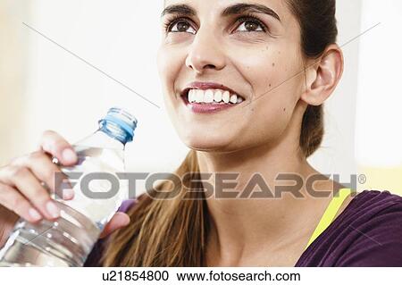 Close up portrait of young woman taking an exercise break drinking water View Large Photo Image Stock Image - Close up portrait of young woman taking an exercise break drinking water. Fotosearch