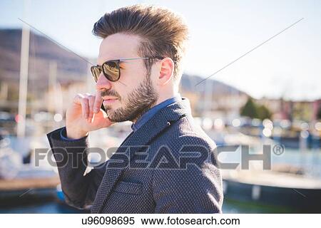 Cool young man talking on smartphone in harbor View Large Photo Image Stock Photography - Cool young man talking on smartphone in harbor. Fotosearch