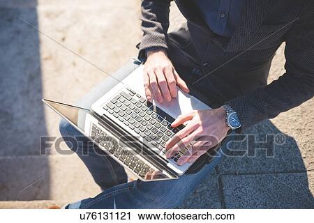Cropped high angle view of young man using laptop on step View Large Photo Image Stock Image - Cropped high angle view of young man using laptop on step. Fotosearch