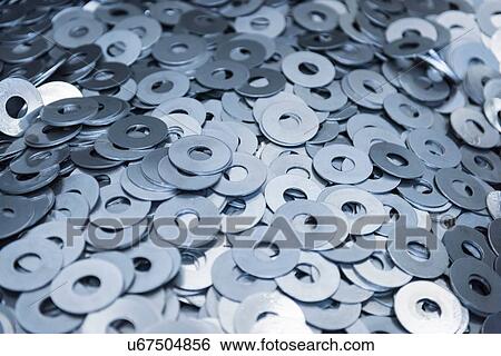 Stock Photograph - Cut metal washers in engineering factory, close up. Fotosearch