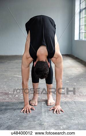 Stock Image - Dancer stretching in studio. Fotosearch