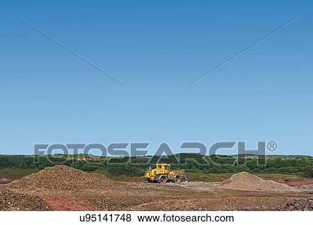 Stock Photo - Digger burying waste on landfill site. Fotosearch