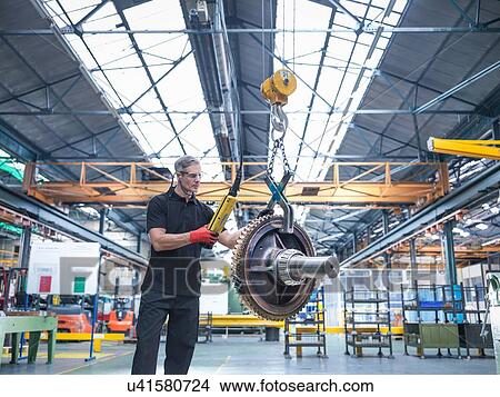 Picture - Engineer assembling industrial gearbox in engineering factory. Fotosearch