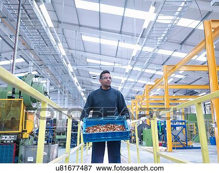 Engineer carrying product in engineering factory View Large Photo Image Stock Photo - Engineer carrying product in engineering factory. Fotosearch
