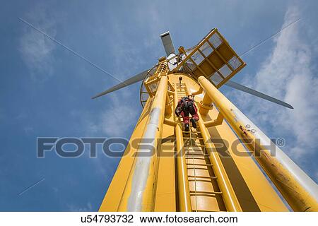 Engineer climbing ladder of wind turbine from boat at offshore windfarm View Large Photo Image Stock Image - Engineer climbing ladder of wind turbine from boat at offshore windfarm. Fotosearch