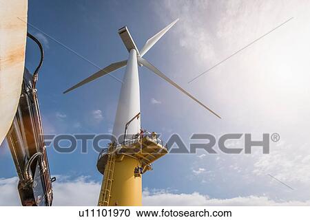 Engineer climbing wind turbine from boat at offshore windfarm View Large Photo Image Stock Image - Engineer climbing wind turbine from boat at offshore windfarm. Fotosearch