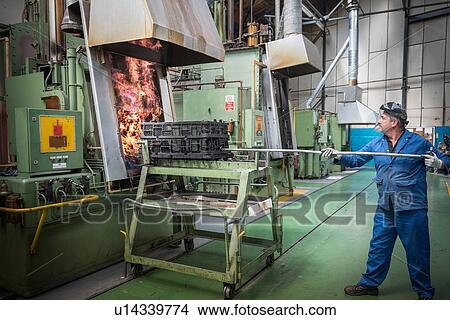 Picture - Engineer heat treating gear wheels in engineering factory. Fotosearch