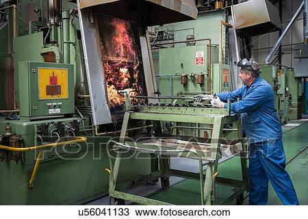 Stock Image - Engineer heat treating gear wheels in engineering factory. Fotosearch